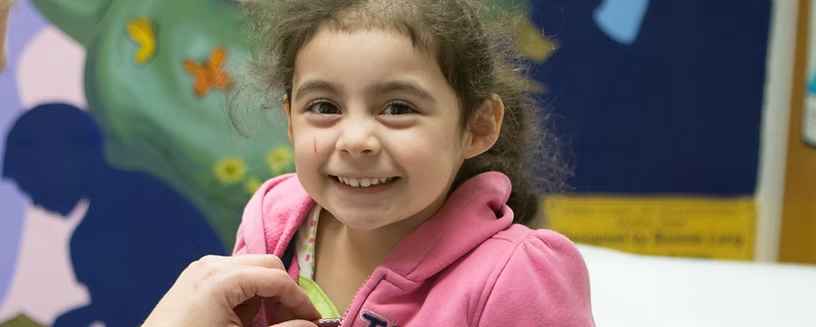 Nurse using a stethoscope with a young patient